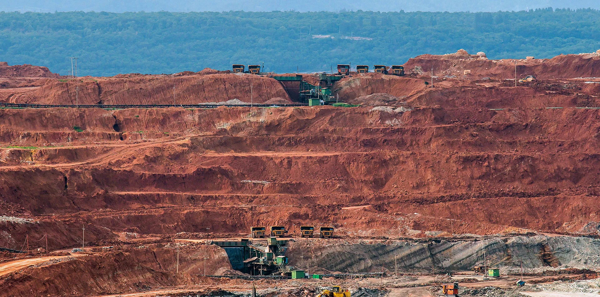 Terraced open-pit copper mine with haul trucks on the benches